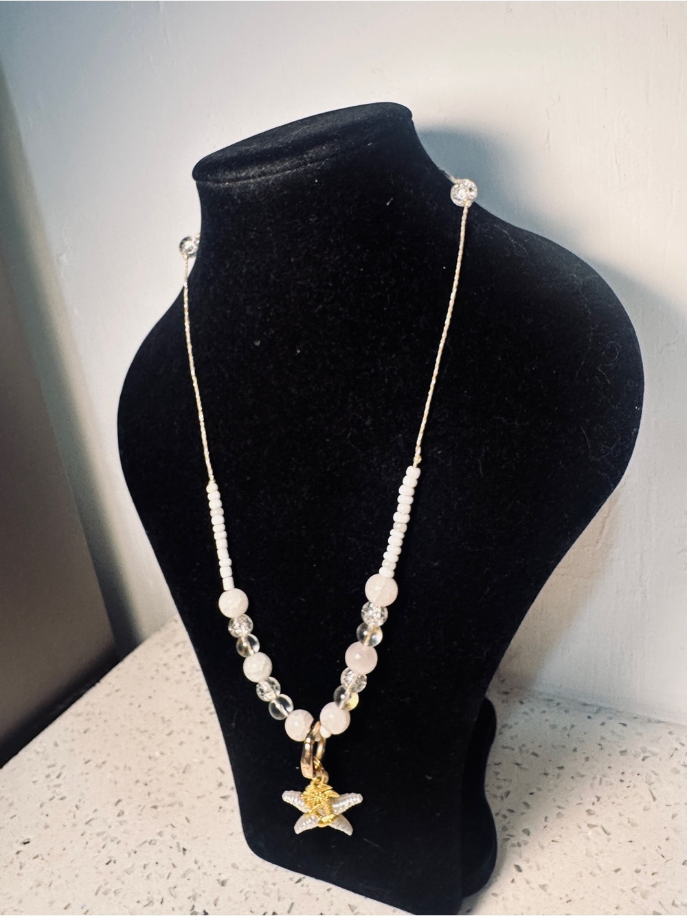 Delicate White Beaded Necklace with Gold Starfish Pendant and gold palm.